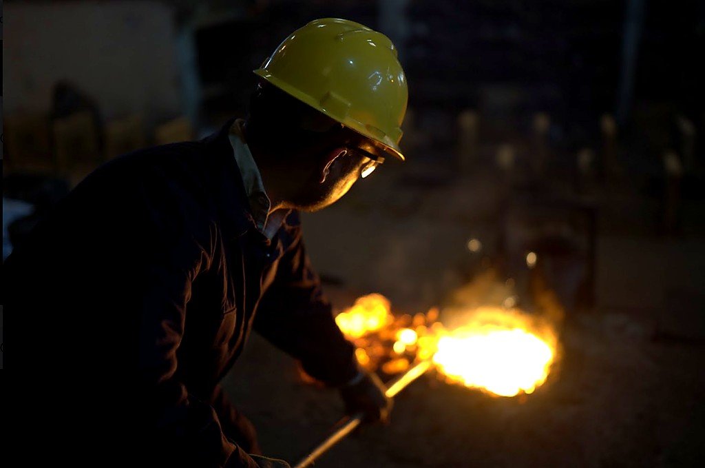 Foundry worker managing molten metal during sand casting at Chenab Engineering Works