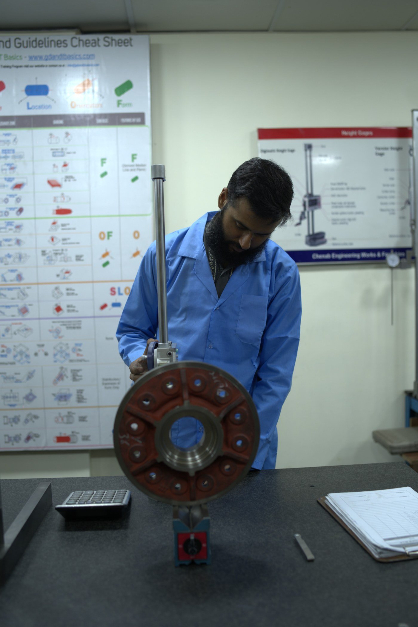 Quality engineer measuring cast components with height gauge against GD&T guidelines